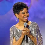 Gladys Knight smiling onstage with a microphone for the Gladys Knight husband profile